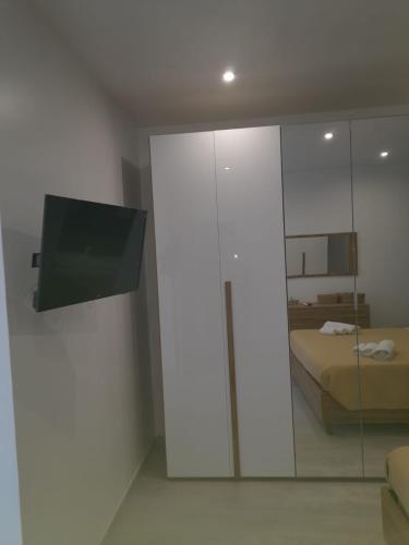 a bedroom with a bed and a tv on a wall at La Terrazza di Porticello in Porticello