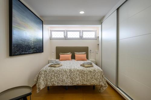 a bedroom with a bed with pink pillows on it at Villa Viña del Mar in Maspalomas