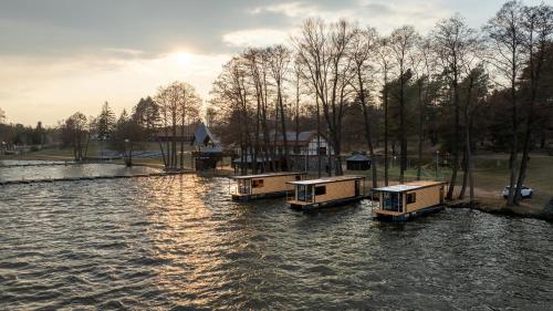 three boats sitting in the water in a river at Domek na wodzie - Marina & Camping Siemiany in Siemiany