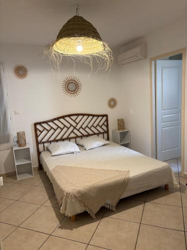 une chambre avec un grand lit et un lustre dans l'établissement Maison au Grau d Agde, au Grau-dʼAgde