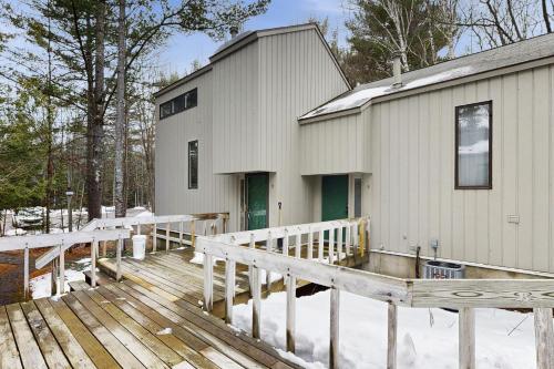 a house with a deck next to a building at Harbor Cove #9 in Harbor Springs