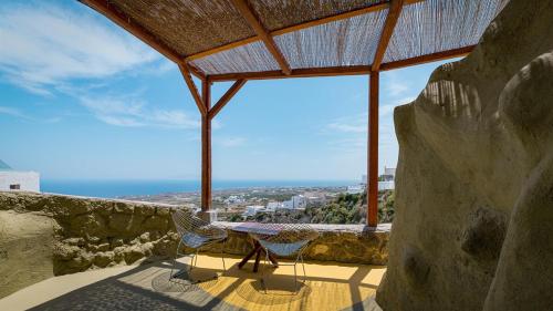 a table and two chairs on a balcony with a view of the ocean at Canyon Santorini in Fira