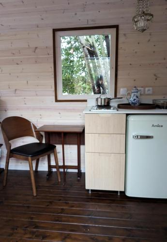 une cuisine avec une table et une chaise ainsi qu'une fenêtre dans l'établissement Roulotte avec terrasse à Montreuil, à Montreuil