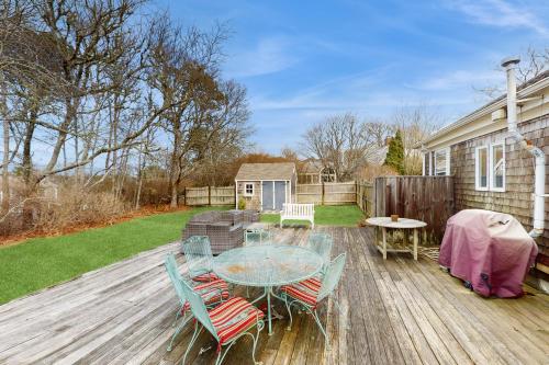 a patio with a glass table and chairs on a deck at Lucky Number Seven in Chatham