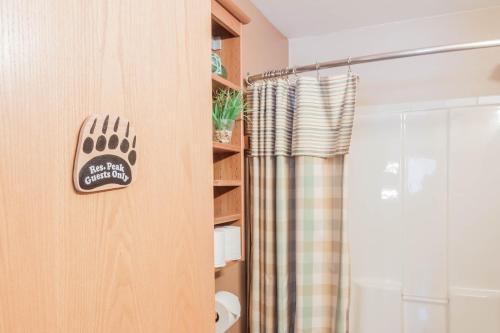 a bathroom with a shower with a paw sign on the door at Bear Lake Lodgings B&B, Inc in Seward