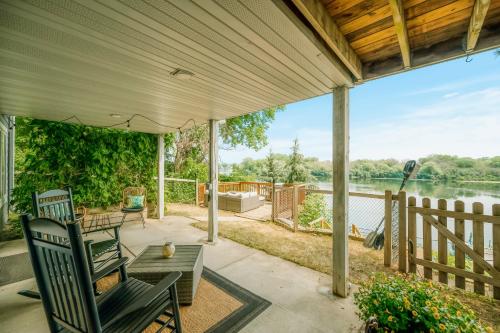 a porch with chairs and a table with a view of a lake at Koselig Cottage on Medicine Lake in Minneapolis