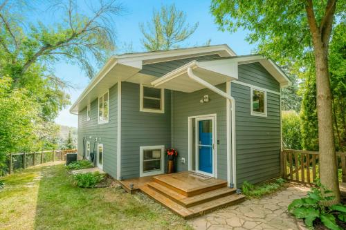 a green tiny house with a porch and stairs at Koselig Cottage on Medicine Lake in Minneapolis