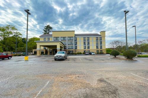 a large yellow building with a car parked in a parking lot at OYO Townhouse Jackson - Ridgeland in Jackson
