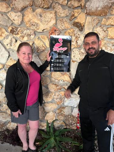 a woman and a man standing in front of a stone wall at Flamingo Inn Beachfront - Daytona Beach in Daytona Beach