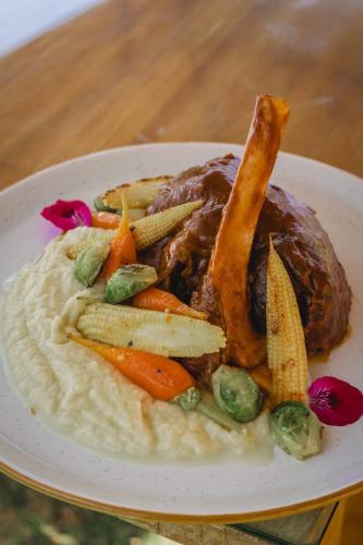 a plate of food with meat and vegetables on a table at Lizzy Wasi Urubamba in Urubamba