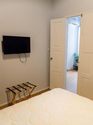 a bedroom with a bed and a flat screen tv on the wall at Byzantium Suite in the centre of Hermoupolis in Ermoupoli