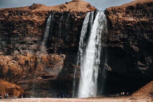 a waterfall on the side of a mountain at Eyja Mork - Stargazing Igloo with shared Hot Tub, BBQ and kitchen - B3 in Stora Mork