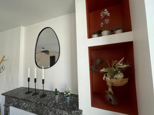 a mirror on a wall next to a counter with plants at Studio à 6 mins de l'hypercentre in Caen