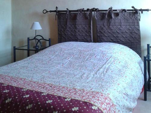 - un lit avec une couverture dans l'établissement La Magnanerie, à Rosières