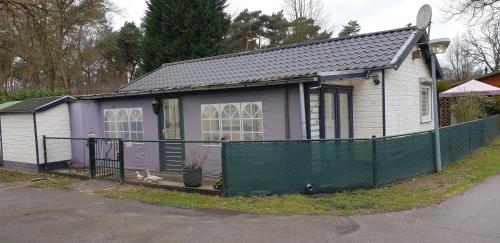 HeelにあるChalet J151の前に緑の柵のある小さな家
