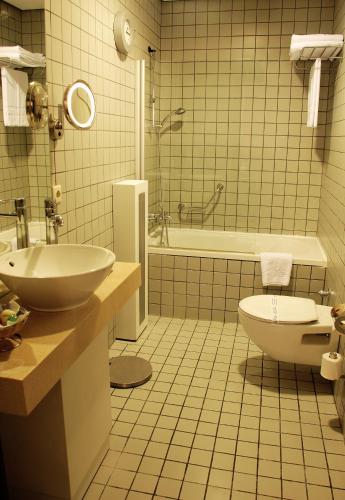 a bathroom with a sink and a toilet and a tub at MY Hotel in Izmir
