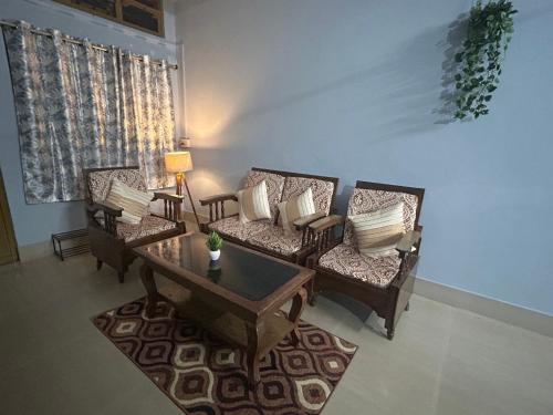 a living room with two chairs and a coffee table at Urban Escape in Silchar