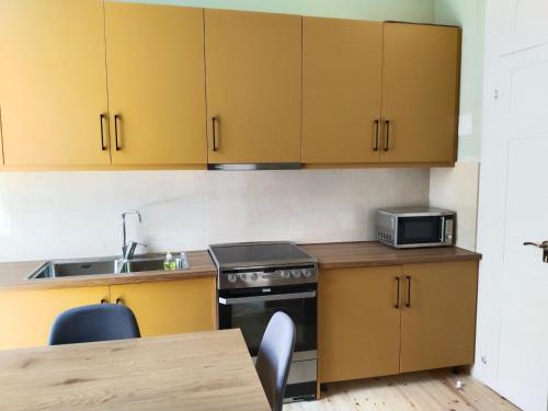 a kitchen with yellow cabinets and a stove and a table at 1920 Classic in Kalamata