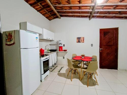 a kitchen with a table and a white refrigerator at Apê da Mel in Galinhos