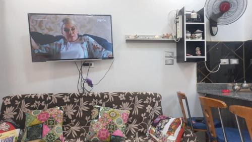 a living room with a couch with a tv on the wall at Juliana Beach Resort in Hurghada