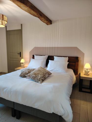 a large white bed with two pillows on it at Gite Les Platanes in Lhuis