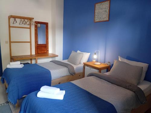 a room with three beds with blue walls at merih butik hotel in Bodrum City