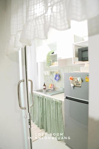 a kitchen with a sink and a refrigerator at Cozy room in Khlongluang - Self Check-in in Khlong Luang