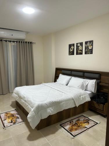 a bedroom with a large bed with posters on the floor at Hurghada Holiday Studio with Beach in Hurghada