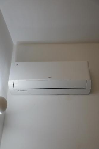 a white tv sitting on top of a ceiling at Magi Rooms in Scafati