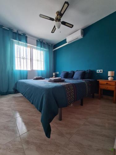a blue bedroom with a bed and a ceiling fan at Casa Blancos in Rojales