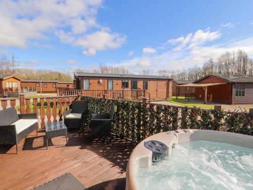 a hot tub on the deck of a house at Duckling Lodge in Carnforth