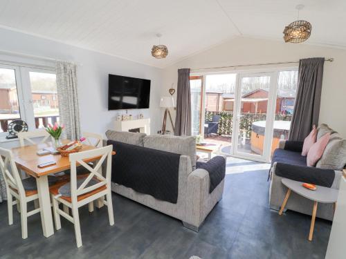 a living room with a couch and a table at Duckling Lodge in Carnforth