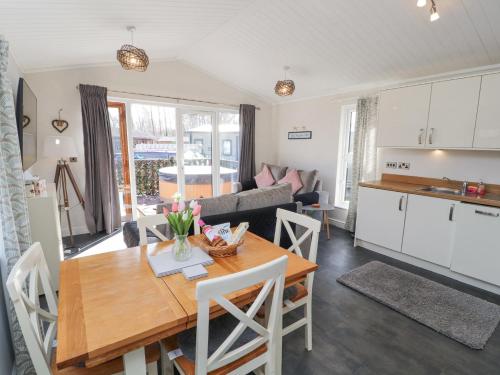 a kitchen and living room with a wooden table and a kitchen and a living room at Duckling Lodge in Carnforth