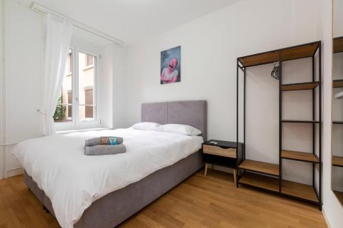 a white bedroom with a large bed and a mirror at KAYA Zurich Apartment 1B - Deluxe 2BR Downtown Apt in Zürich