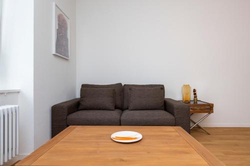 a living room with a couch and a table at KAYA Zurich Apartment 1B - Deluxe 2BR Downtown Apt in Zürich