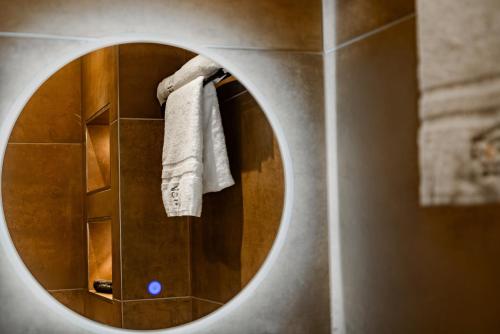 a mirror in a bathroom with towels on a wall at Domo Boutique Hotel Birmingham in Birmingham