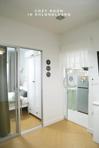 a kitchen with a sliding glass door in a room at Cozy room in Khlongluang - Self Check-in in Khlong Luang