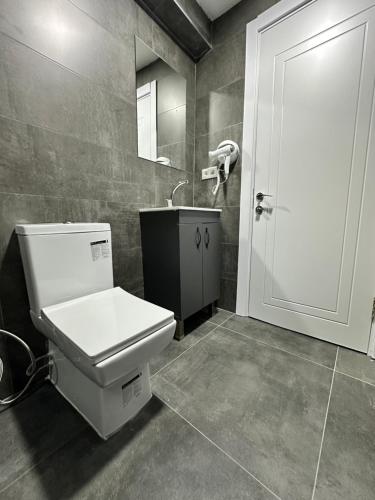 a bathroom with a toilet and a sink and a door at Piola Hotel Kadıköy in Istanbul