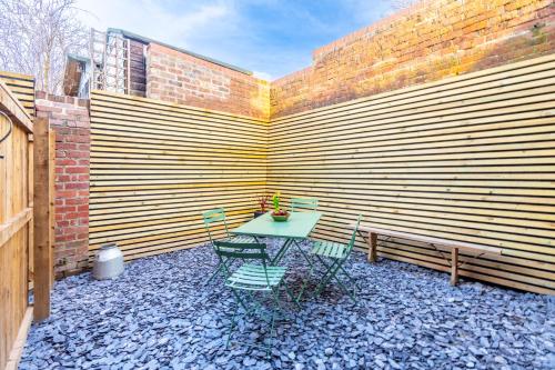 a patio with a table and chairs and a bench at The Willows Boutique Stays Central Whitby in Whitby
