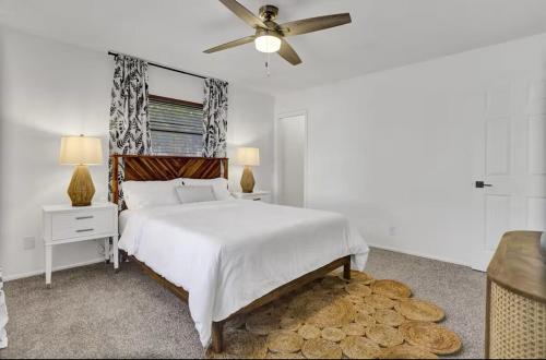 a white bedroom with a bed and a ceiling fan at Welcome to the Leaf House in Delray Beach