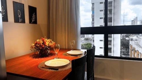 a dining room table with two chairs and a window at Max Derby - Studios no Centro do Recife por Yolo in Recife