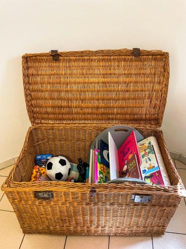 a wicker basket filled with books and a soccer ball at Appartement T3 à 5km de la plage in Labenne