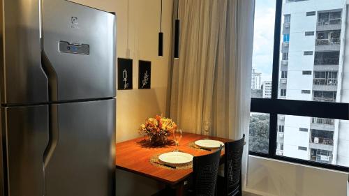 a kitchen with a table with a refrigerator and a window at Max Derby - Studios no Centro do Recife por Yolo in Recife