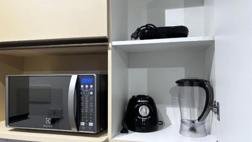 a kitchen with a microwave and a blender on a shelf at Max Derby - Studios no Centro do Recife por Yolo in Recife
