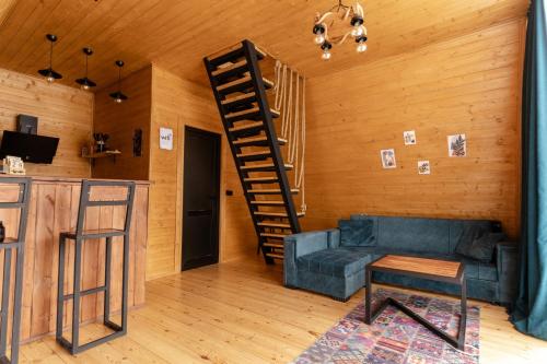 un soggiorno con divano e una scala a chiocciola di Vista cottage a Kazbegi