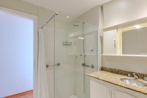 a bathroom with a glass shower and a sink at Vista Carioca in Rio de Janeiro