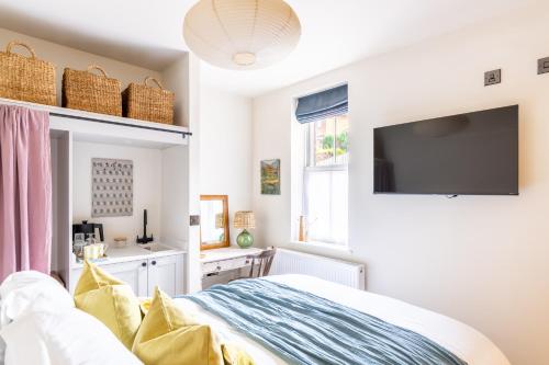 a bedroom with a bed and a flat screen tv at The Willows Boutique Stays Central Whitby in Whitby