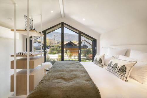 une chambre avec un grand lit et une grande fenêtre dans l'établissement La Villa 227 - Lac Annecy, à Saint-Jorioz