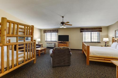 a bedroom with a bed and a couch and a tv at Stoney Creek Hotel St. Joseph in Saint Joseph