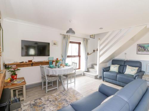 a living room with a blue couch and a table at 5 The Coach House in Haverfordwest